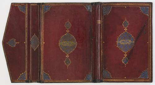 Interior bookbinding, open and laid flat. The interior is red with central medallions and cornerpieces of brown leather filigree over blue grounds, the central medallions also containing a pious phrase filigreed in thuluth script.