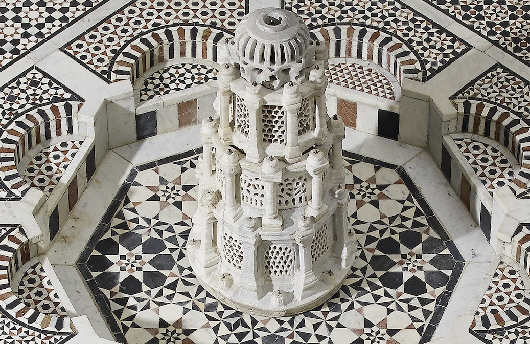An ornately tiled base with a minaret-like fountain at the centre.