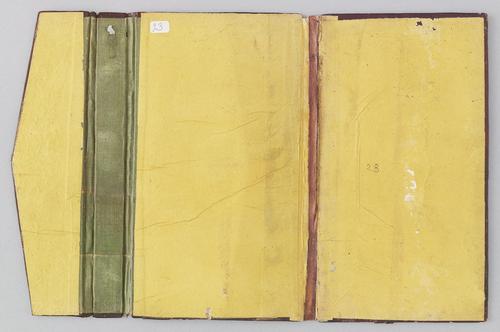 Inside of a Turkish book binding with flap, laid open flat. The inner cover is yellow, with visible wear, spine is brown and the spine of the flap is green.