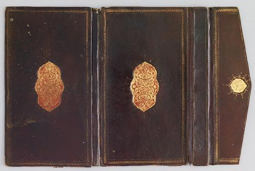 Outer cover of dark-brown Turkish book binding with flap, laid flat. There is a gilt rope border, a gilt-stamped medallion in the centre; medallion is gold with embossed vines and some red in the background. Both sides are a mirror image of one another. Flap is a dark-brown leather with gilt rope and small gold embossed medallion