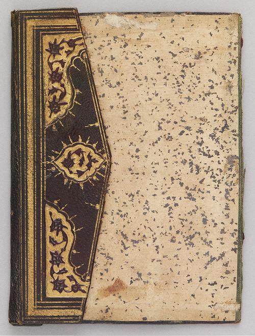 One side of doublure of Turkish book binding, with the flap folded over. The inner cover is aged yellow, with brown specks. The flap of the book binding has a gilt embossed central medallion.