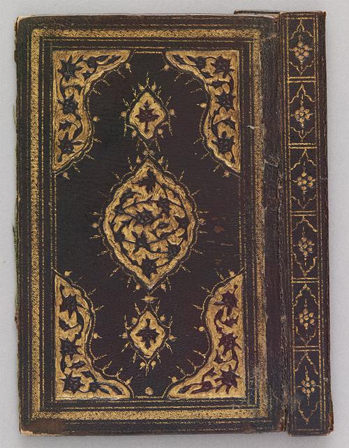 Outer cover and spine of a dark-brown Turkish book binding. There is a central gilt embossed medallion with pendants and corners decorated with gilt embossed patterns. The spine of the book binding has a repetition pattern of smaller floral pendants which are also gilt embossed. 