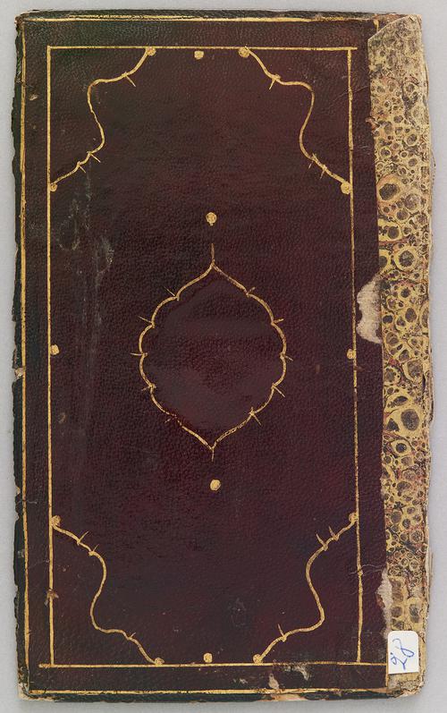 Interior of a bookbinding cover faced with light chestnut-coloured leather decorated with a central medallion and cornerpieces drawn in gold with a brush. Marbled paper has been pasted down on one edge. 
