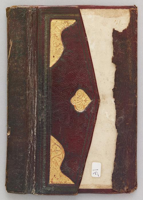 Leather bookbinding flap folded over on top of the interior back cover, the flap has a medallion with broad lobes and corner pieces, filled with stamped gilded designs of branches and flower-like shapes.