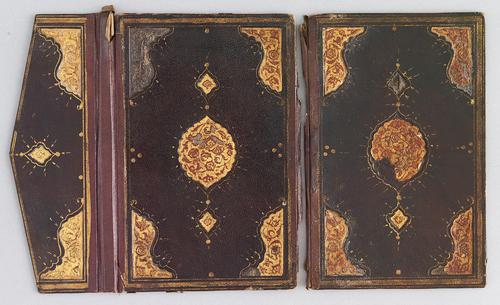 Outer cover of dark-brown Turkish book binding with flap, laid flat. There is a gilt-stamped gold border, a centre gold and red medallion along with similar corner motifs. The flap has gilt-stamped border with a smaller gold medallion. 