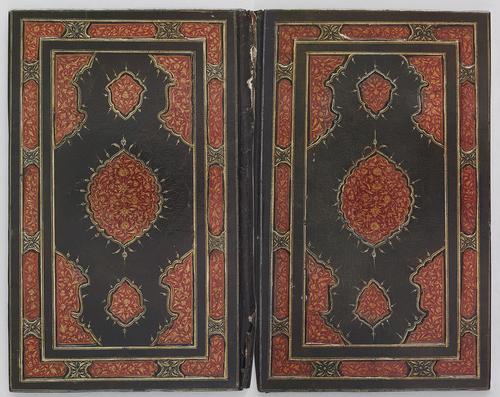 Dark green leather bookbinding, laid open flat. Both sides of the bookbinding contain mirror images. Red and gold gilt-stamped border, with intricate floral patterns. Centre medallion is also red, and gold gilt-stamped with similar floral patterns as the border. 