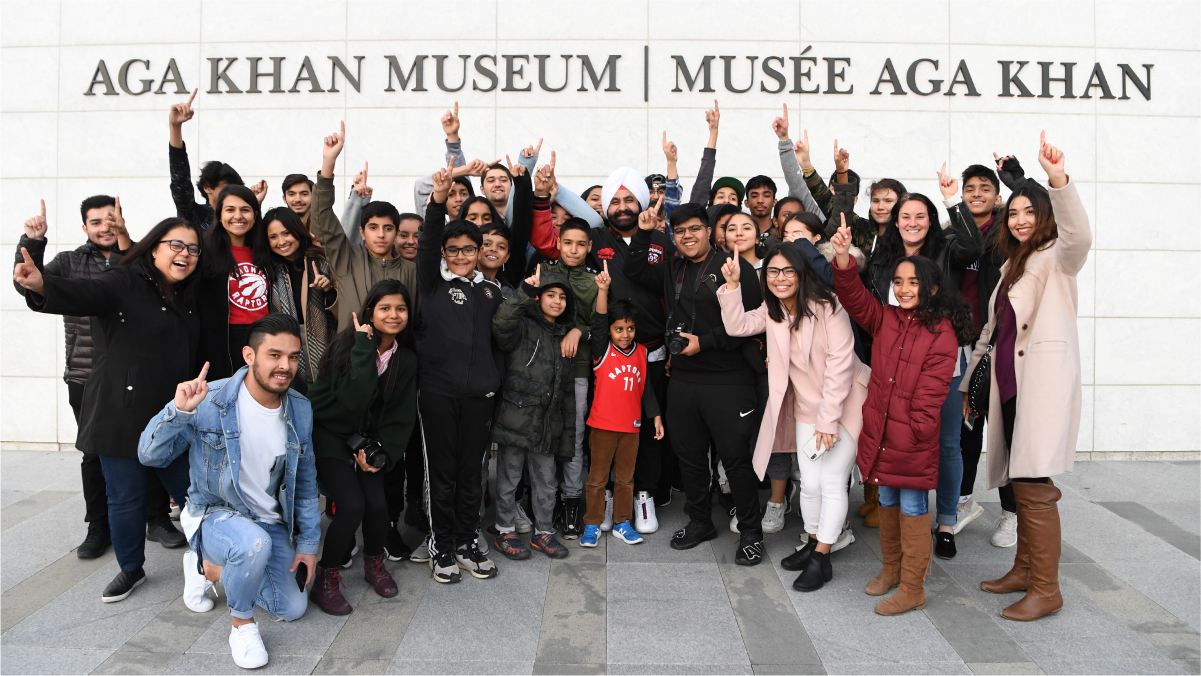 Three dozen children and teens surround Nav Bhatia, Toronto Raptors Superfan, outside the Aga Khan Museum.