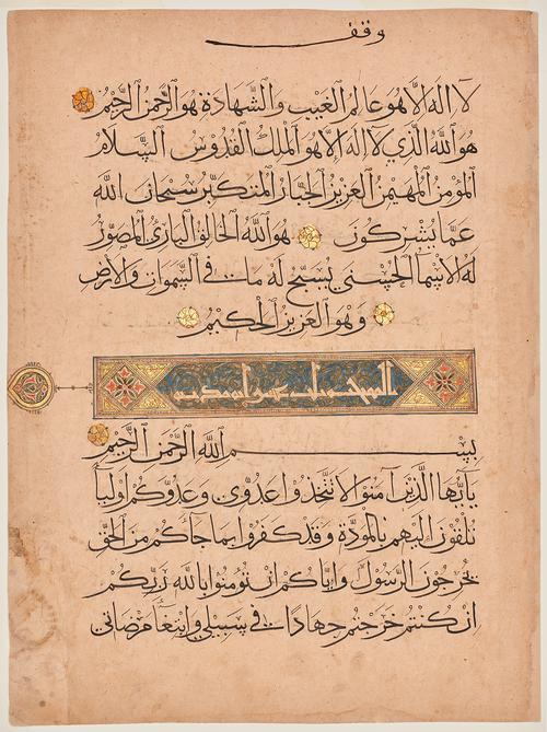 Page from a manuscript, 5 lines/script of text with Gold rosettes mark between verses.  In the centre an illuminated rectangle with script inside, inside each end of the rectangle, diamond containing a cruciform arrangement of pink trefoils and dark blue lancets upon pale green, surrounded by gold foliate scroll-pattern.