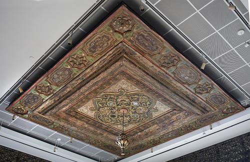 Woodend architectural element, square with intricate carvings, cartouches and medallions. Installed on a ceiling with a light fixture in the centre