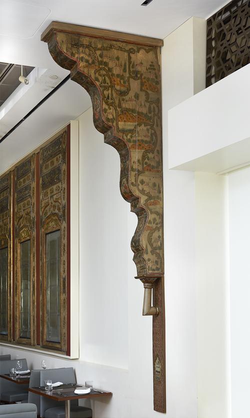 Wood corbel decorated with landscape imagery installed on a white wall