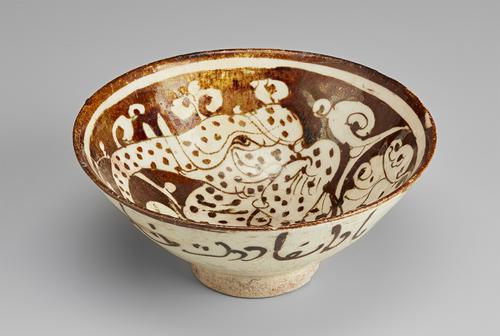 View of a circular bowl, decorated in a brown paint over a cream background. The base is small and raised. The inside of the bowl shows an elephant-headed bird surrounded by clouds, with bands of white and brown around the rim. The exterior is decorated simply with verses of poetry.