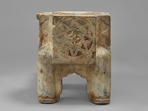 Back view of the, back two legs, and an eight-pointed star carved into the back surface of the Kilga