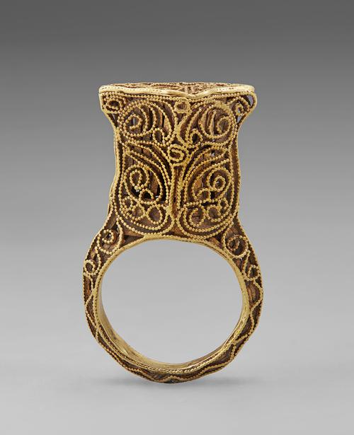 Side view of the golden ring standing straight up on its band. Side view of the filigree and granulation that create this ring.  
