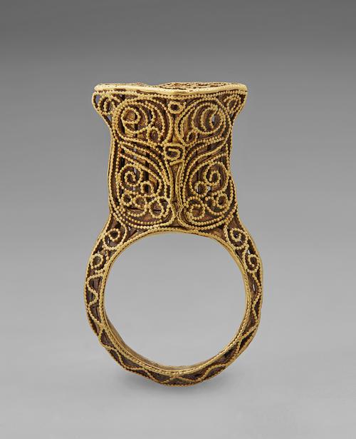 Opposite side view of the golden ring standing straight up on its band. Side view of the filigree and granulation that create this ring.  