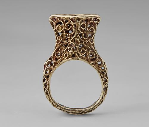 View of the golden ring featuring filigree and granulation standing straight up on its band.