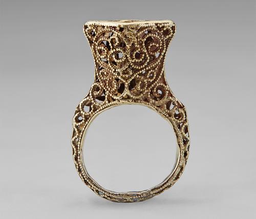 View of the golden ring featuring filigree and granulation standing straight up on its band.