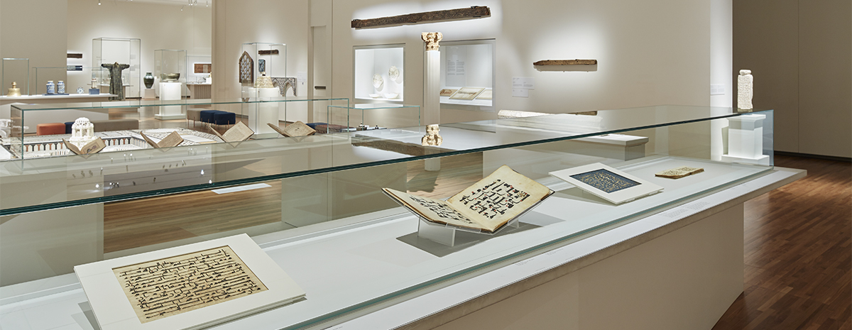 Centuries-old manuscripts featuring Arabic text displayed in a glass case in the Aga Khan Museum's main-floor gallery.