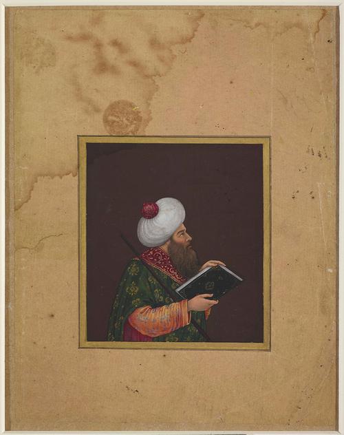 small square painting with large boarder, of a man holding a book, he wears a large white turban and rich dark green velvet robe with a wine-red collar over a saffron jacket decorated with delicate lavender flowers. 