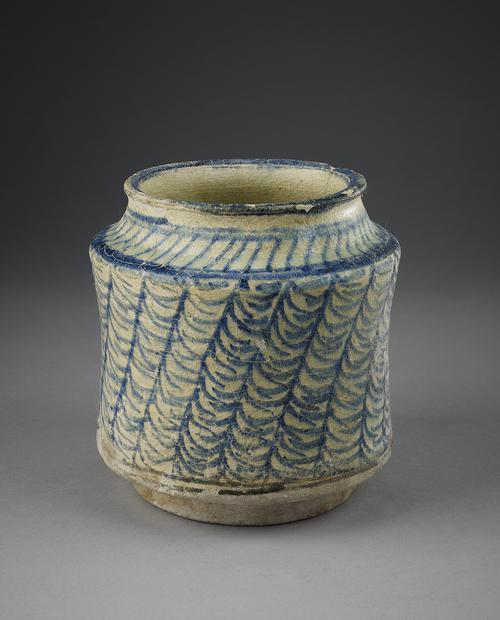 Ceramic jar, of circular shape with short neck, the body decorated with diagonal vertical bands, each painted with asymmetrical chebrons in cobalt-blue against a cream ground.