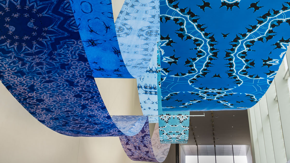 An art installation featuring large-scale fabric scrolls draped across the Museum’s atrium.