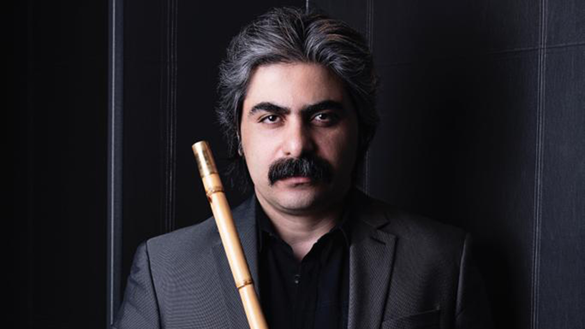 A portrait of Shaho Andalibi holding an Iranian flute known as the ney