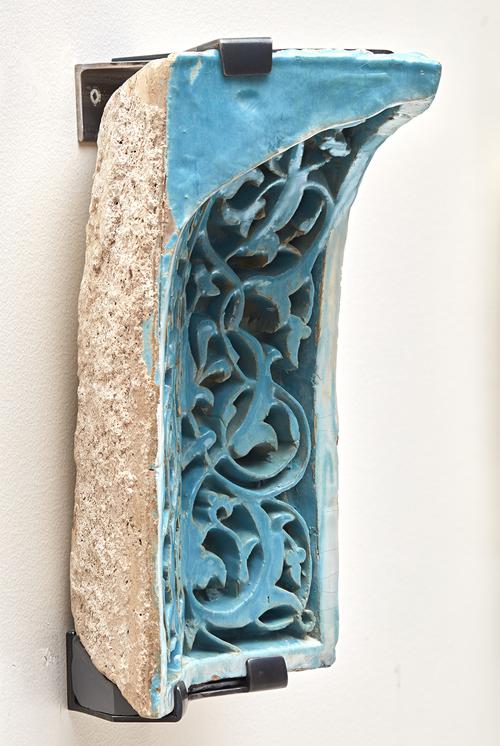 Side of blue turquoise rectangular ceramic tile, concaved with floral carved design. Side is beige unglazed ceramic