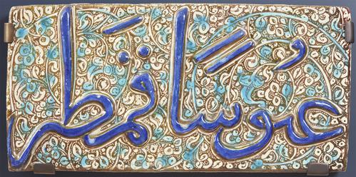 Rectangular ceramic tile decorated with arabic calligraphy.