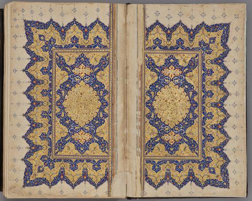 Double page spread, mirrored gold and blue illumination with floral patterns on three sides. At center, an illuminated cartouche within a rectangular panel, with an inscription, and with floral patterns in pale pink, yellow   
