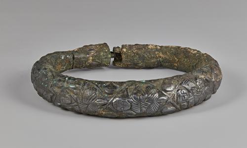 One of two silver arm bracelets, engraved, the front of this bracelet shows three of the five figures. Showing signs of corrosion on all sides.