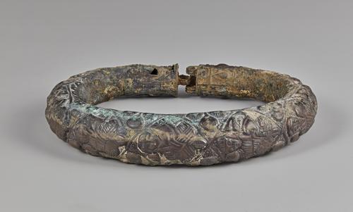 One of two silver arm bracelets, engraved, the front of this bracelet shows four of the five figures. Showing signs of corrosion on all sides.