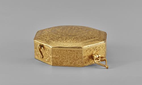 Gold Qur’an case was worn as an arm ornament. The palmette-shaped loops on either side of the box indicate how it originally would have been tied with a silk string around the bicep.