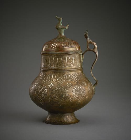 Tankard of squat bulbous form on a narrow splayed foot, the broad straight neck rising to a domed cover with a modelled bird finial, the flattened s-shaped handle, decorated with engraving of foliate forms. 