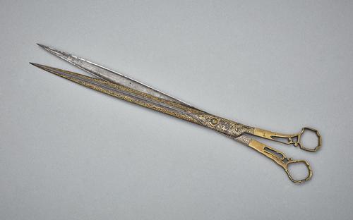 Gold damascened steel scissors in an open position. 