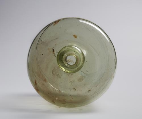 View looking down through the narrow rim, rounded mouth of a Short glass bubble shaped bottle with blown from colourless glass with a greenish tinge.