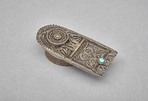 A silver inkwell with a turquoise stud and filigree design.  
