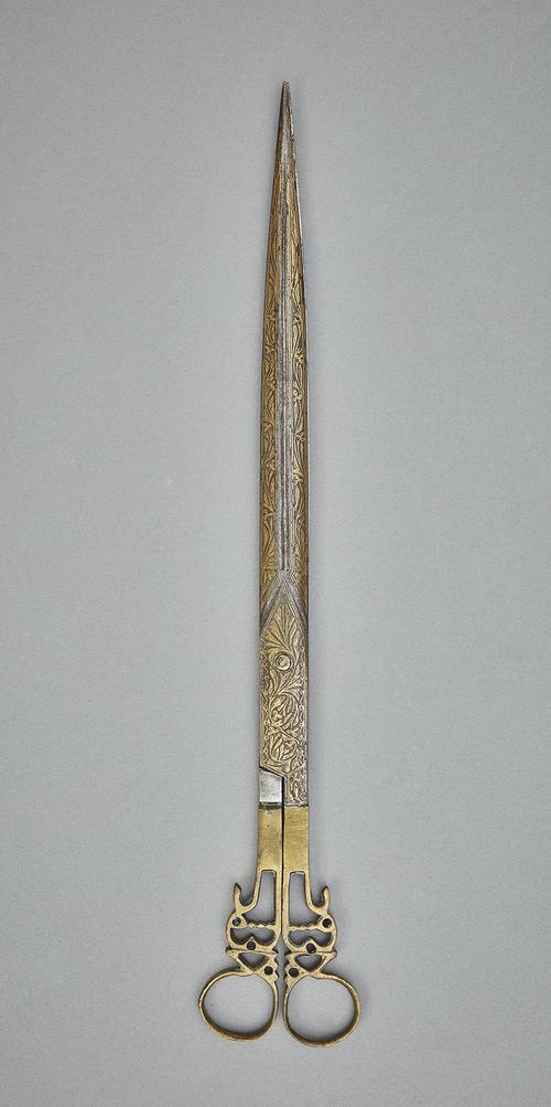 Gold damascened steel scissors in an open position