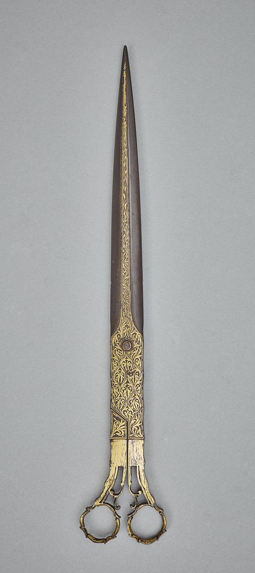 Gold damascened steel scissors in an open position.