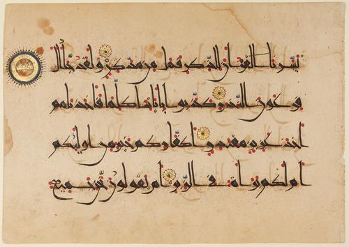 A rectangular folio with four verses in black ink and punctuated by red dots to assist in reading. Four gold rosettes with blue centres indicate the beginning of each verse, and the ending of each group of ten verses is marked by a larger, golden medallion (upper left).